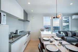 富良野的住宿－ArtHouse by H2 Life，厨房以及带桌椅的用餐室。