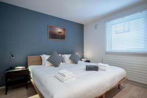 富良野的住宿－ArtHouse by H2 Life，一间卧室配有一张大床和毛巾