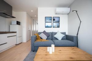 富良野的住宿－ArtHouse by H2 Life，客厅配有蓝色的沙发和桌子