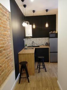 a kitchen with two stools and a sink and a counter at Rooms by Apartamenty Lubartowska Street in Lublin