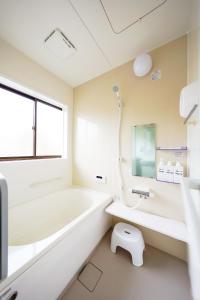 a bathroom with a tub and a sink and a toilet at Second House Nikko in Nikko