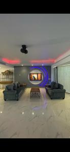 a living room with two couches and a tv at فيلا بمسبح خاص درة العروس in Durat  Alarous