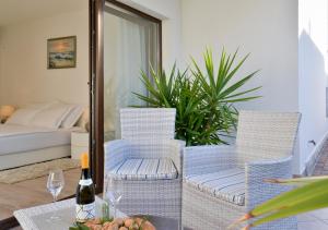 a table with two chairs and a bottle of wine at Apartments Villa Rosi in Umag