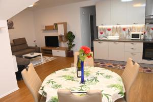 a dining room table with a vase of flowers on it at Apartments Mak in Moravske Toplice