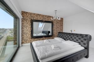 - une chambre avec un lit et un miroir dans l'établissement Comfort Apartments Rezydencja Wintera, à Gdańsk