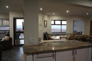 a kitchen and living room with a view of the ocean at Erf Three Seven Eight Langstrand Self-Catering in Langstrand