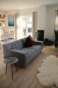 Sala de estar con sofá gris y mesa en Inselliebe, en Oertzenhof