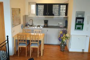 a kitchen with a wooden table and a table and chairs at Campus Apartment Alexander in Dresden