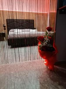 um quarto com um vaso de flores num quarto em Rebel Suite love em Gravina in Puglia