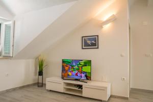 a living room with a tv on a white wall at Apartment Ma_Lu in Pučišća