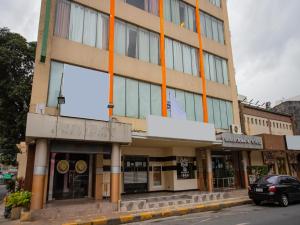 a building with orange columns on a street at Super OYO 838 Manila Crown Palace Hotel in Manila