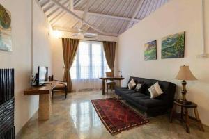 een woonkamer met een bank en een tafel bij Miracle Villa Sanur in Sanur