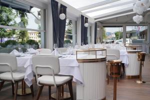 a restaurant with white tables and chairs and windows at Baliktasi City Hotel & Spa in Ordu