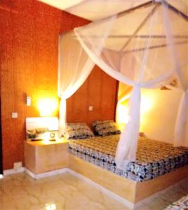 a bedroom with a bed with a canopy at Le Chamama in Niaga