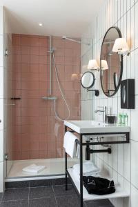 a bathroom with a shower, sink, and mirror at Hotel Bastille Speria in Paris