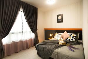 a bedroom with a bed and a large window at Suasana suites By The one in Johor Bahru
