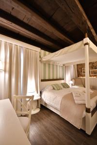 a bedroom with two beds and a canopy bed at Al Palazzetto in Udine