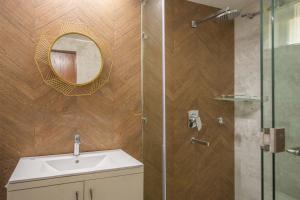 a bathroom with a shower with a sink and a mirror at StayVista at SilverOaks Cottage in Dehradun +32 photos