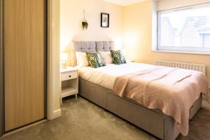 a bedroom with a large bed and a window at Waterside Lodge by PAY AS U STAY in Milton Keynes