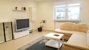 un soggiorno con divano e TV di holiday apartment essen 3 a Essen