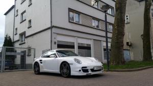 a white porsche car parked in front of a building at holiday apartment essen 3 in Essen