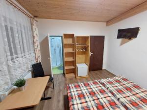 Schlafzimmer mit einem Bett, einem Schreibtisch und einem Fenster in der Unterkunft Penzion Emílie in Jeseník