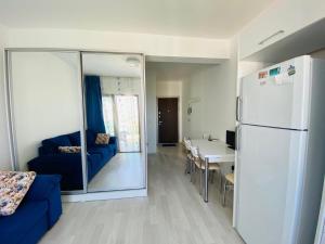 a living room with a blue couch and a refrigerator at Prestige Studios in Kyrenia