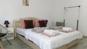 a bedroom with a large white bed with pink pillows at Happy Star in Niš