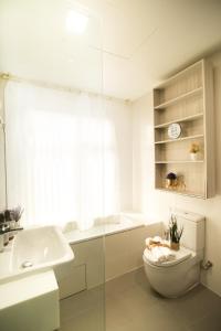 a white bathroom with a toilet and a sink at Suasana suites By The one in Johor Bahru