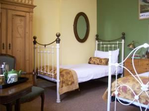 a bedroom with a bed, desk, chair, and lamp at Highland Park House in Kirkwall
