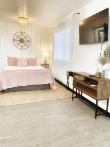 a white bedroom with a bed and a desk at The Shack Inn in Homer