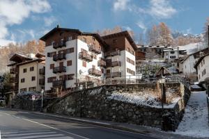 een gebouw aan de zijkant van een heuvel met een straat bij HelloChalet - Maison Mont Fleury- newly refurbished 50 mt center and ski bus stop in Valtournenche