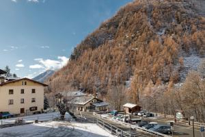 een berg met auto's geparkeerd voor een stad bij HelloChalet - Maison Mont Fleury- newly refurbished 50 mt center and ski bus stop in Valtournenche +40 foto's