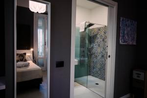 a bathroom with a glass shower and a bedroom at Villa Calipso in Mondello