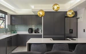 a kitchen with black cabinets and a table with chairs at 1 Licorna Beach in Durban
