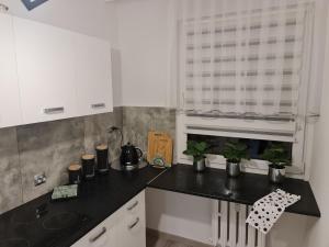 a kitchen with white cabinets and a black counter top at Apartament Nova przy S3 in Nowa Sól
