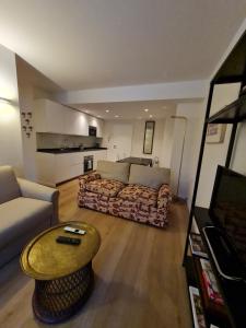 a living room with a couch and a coffee table at Sankt Moritz Dorf Charme Apartment in St. Moritz