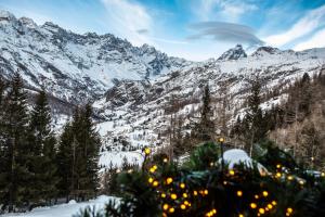 een kerstboom voor een met sneeuw bedekte berg bij HelloChalet - Maison Mont Fleury- newly refurbished 50 mt center and ski bus stop in Valtournenche