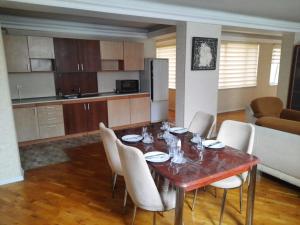 a dining room table with chairs and a kitchen at Compleks Hostel of Nizami street in Baku