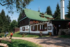 una casa con gente parada fuera de ella en Penzion La Baita, en Branná