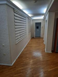 an empty room with a hallway with a wooden floor at Compleks Hostel of Nizami street in Baku