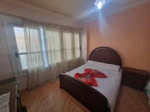 a bedroom with a bed with a red ribbon on it at Panoramic Sea View Flat miami FAMILY ONLY شقة بانورما بشاطئ ميامي الاسكندرية عائلات فقط in Alexandria
