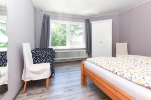 a bedroom with a bed and a chair and a window at Ferienhof Tannen in Stedesdorf