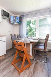 a kitchen with a wooden table with chairs and a dining room at Ferienhof Tannen in Stedesdorf