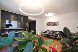 uma sala de estar com um sofá e uma televisão em Habitat Apartments em Trento
