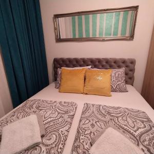 a bed with two pillows on top of it at Daniris apartman in Novi Sad