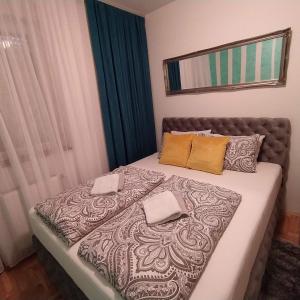 a bedroom with a bed with two pillows on it at Daniris apartman in Novi Sad