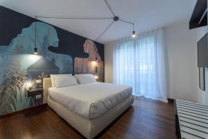 a bedroom with a bed and a painting on the wall at Habitat Apartments in Trento