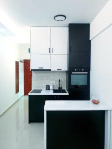 a kitchen with black appliances and white cabinets at LUX Apartment - Central Place Bar in Bar