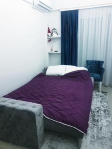 a bedroom with a purple bed and a blue chair at LUX Apartment - Central Place Bar in Bar